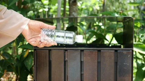 Women hand throwing an empty plastic water bottle in the garbage trash or bin Stock Footage 202084680