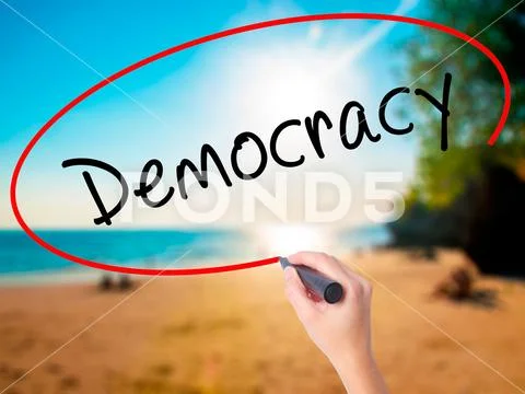 Women Hand writing Democracy with black marker on visual screen Stock Photos