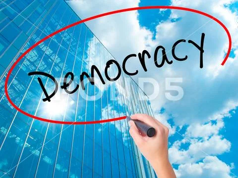 Women Hand writing Democracy with black marker on visual screen Stock Photos