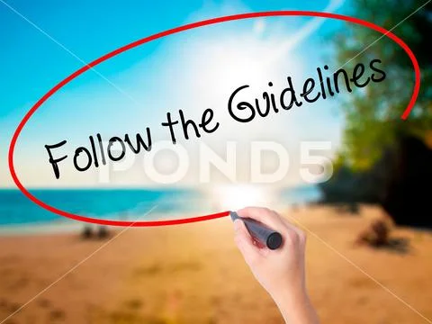 Women Hand writing Follow the Guidelines with black marker on v Stock Photos