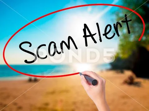 Women Hand writing Scam Alert with black marker on visual scree Stock Photos