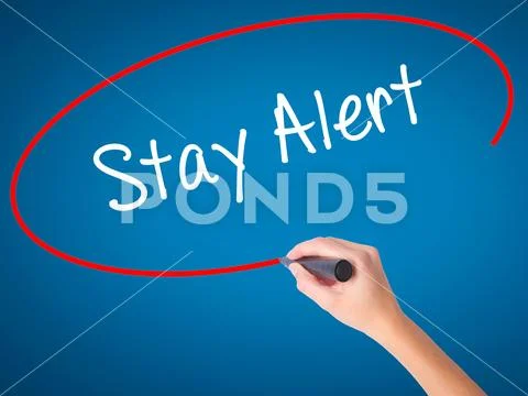 Women Hand writing Stay Alert with black marker on visual screen Stock Photos