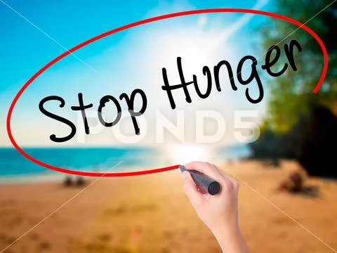 Women Hand writing Stop Hunger with black marker on visual scre Stock Photos