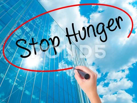Women Hand writing Stop Hunger with black marker on visual scre Stock Photos