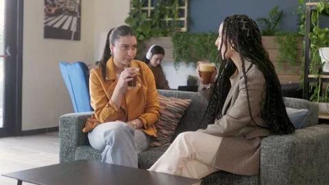 Women having serious conversation while having coffee at coffee shop Stock Footage 244602368