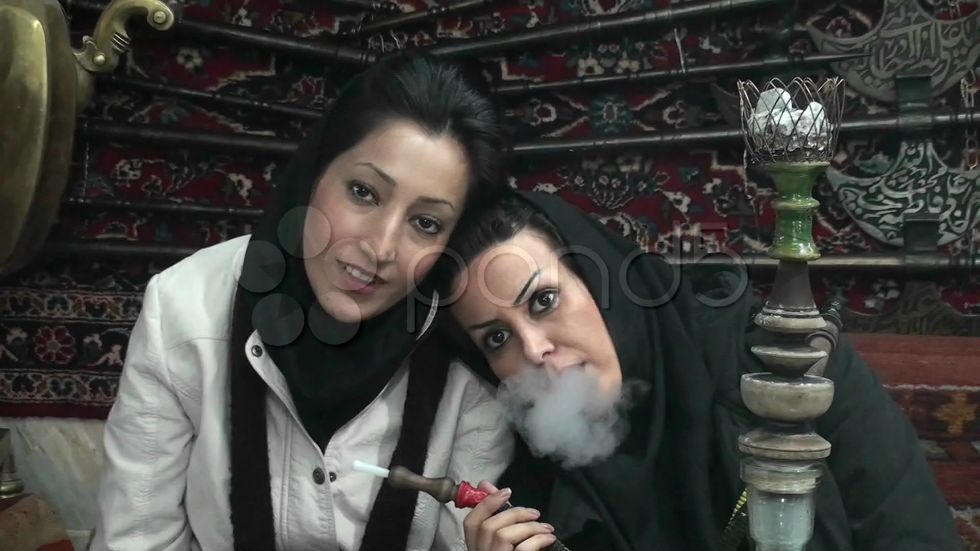 Women in headscarfs smoke a hookah pipe ... | Stock Video | Pond5