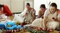 Women in Hindu traditional colorful costumes makes flower wreaths HD Footage
