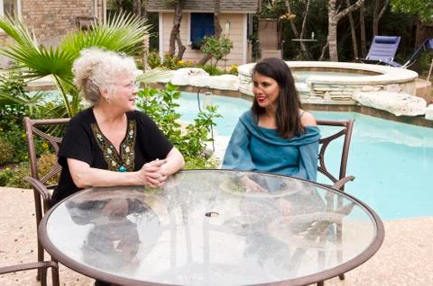 Women  interacting at pool side table Stock Photos
