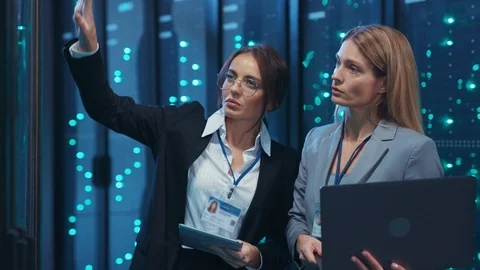 Women IT server technicians inspecting a rack cabinet, touching virtual Video stock 120797292