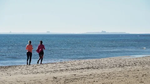 Women jogging on the beach Stock Footage 89700382
