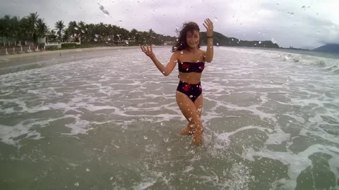 Women jumping in ocean waves. Stock Footage 99813975