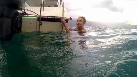 Women jumping in ocean waves. 库存影片 99813992