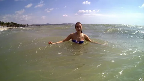 Women jumping in ocean waves. Stock Footage 99813998