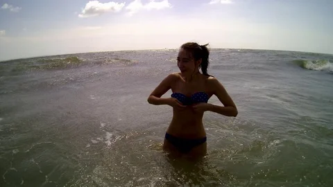 Women jumping in ocean waves. Stockbeeldmateriaal 99814006