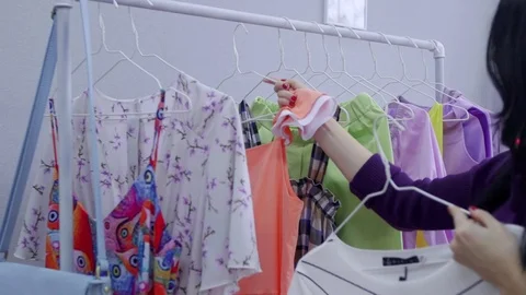 Women looking through clothes rail in clothing store Stock-Footage 79746121