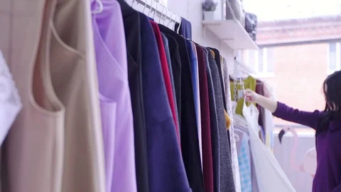 Women looking through clothes rail in clothing store Stock Footage