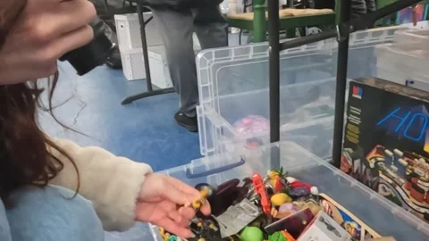 Women Looking Through Toys at the same Time Taking Pictures at a Toy Fair. Stock Footage 300916457