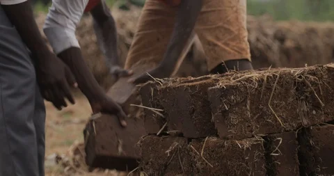 Women make Bricks from adobe pressing wet mud mixture into timber frame Stock Footage 109139645