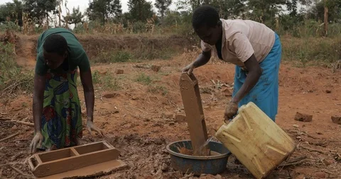 Women make Bricks, pressing mud mixture into an open timber frame, Mbale, Uganda Stock Footage 109492101