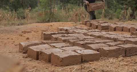 Women make Bricks, pressing mud mixture into an open timber frame, Mbale, Uganda Stock Footage 109492940
