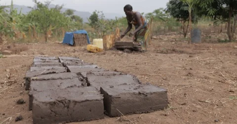 Women make Bricks, pressing mud mixture into an open timber frame, Mbale, Uganda Stock Footage 109495426