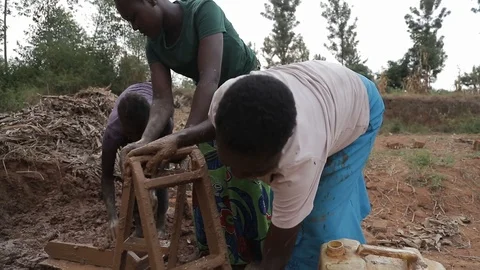 Women make Mud Bricks pressing wet mixture into a timber frame, jinja, uganda Stock Footage 109140033