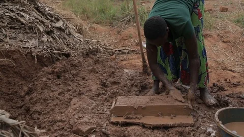Women make Mud Bricks pressing wet mixture into a timber frame, jinja, uganda Stock Footage 109140069