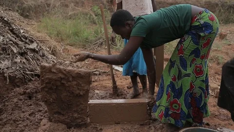 Women make Mud Bricks pressing wet mixture into a timber frame, jinja, uganda Stock Footage 109140090