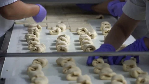 Women make rolls on in a bakery on a conveyor belt. Hands close up Stock Footage