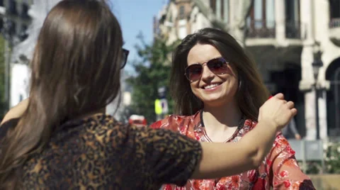 Women meeting and hugging on the street, slow motion shot at 120fps Stock Footage