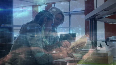 Women opening reference book and accessing laptop while digital overlay guiding Stock Footage 313678297