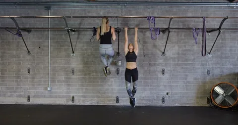 Women perform abs workout on the pull up bar in gym in slow motion Stock Footage 97358355