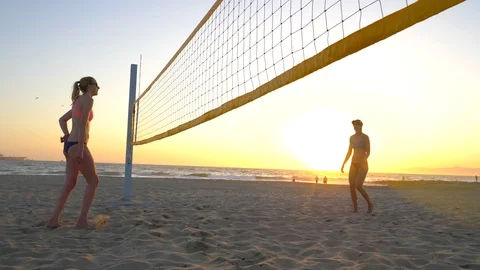 Women players play beach volleyball and a player hitting spiking the ball, slow Stock Footage