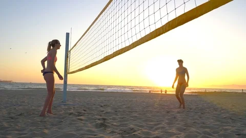 Women players play beach volleyball and a player hitting spiking the ball. Stock Footage