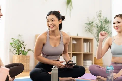 Women practice yoga in a studio while enjoying a relaxed conversation durin.. Stock Photos