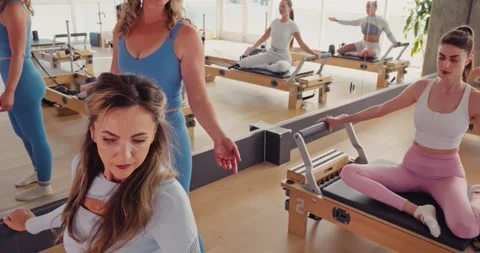 Women Practicing Pilates in a Modern Studio Stock Footage 323930760