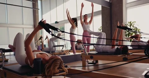 Women Practicing Pilates in a Modern Studio 스톡 동영상 323935341