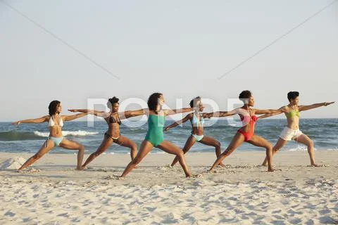 Women practicing yoga on beach Stock Photos