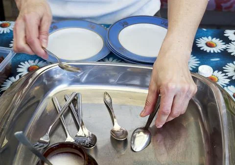 Women preparing plates and cutlery to eat desert. Selective focus on cutleries Stock Photos
