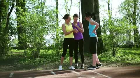 Women running on the track, trainer checking their time, dolly shot HD Stock Footage 10922702
