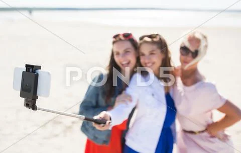 Women with selfie stick and smartphone on beach Stock Photos