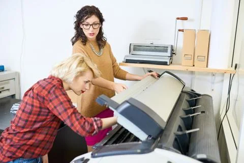 Women Setting Up Plotter Stock Photos