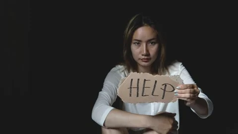 Women sitting alone with depressed expression and showing a paper with a help Stock Footage 201995247