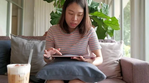 Women sitting on sofa and  using tablet computer for social network. Stock Footage 135347418