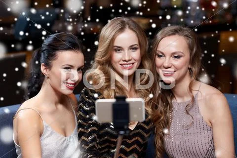 Women with smartphone taking selfie at night club Stock Photos