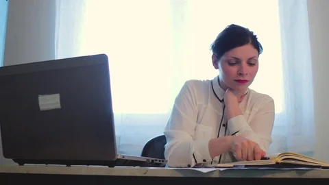 Women solving problems by writing and typing on computer Stock Footage 82548206