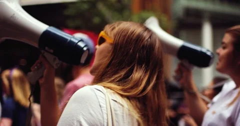 Women speaking in loudspeaker during protest march Stock Footage