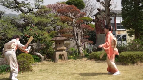 Women toss a ball while wearing formal kimonos Stock Footage 343707706