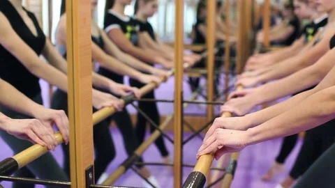 Women training dance step in studio near mirror and wooden crossbar Stock Footage 85083874