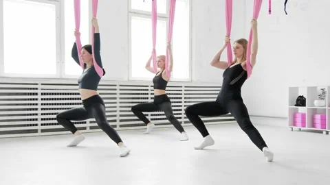 Women training using anti-gravity yoga hammock. Fitness program with hammocks. Stock Footage 236458300